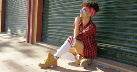 Gorgeous african american girl sitting next to fenceの写真素材