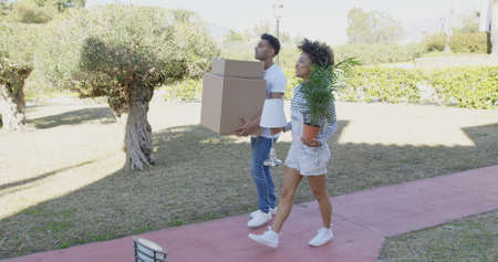 Young couple moving house carrying boxesの写真素材