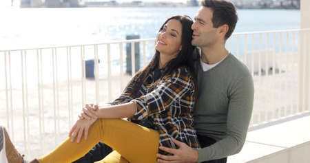 Loving young couple relaxing at the waterfrontの写真素材