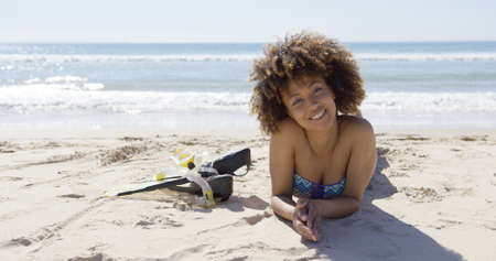 Female lying on beach with flippersの写真素材