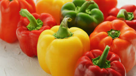 Bunch of bright multicolored bell peppers composed in bunch on wooden table
