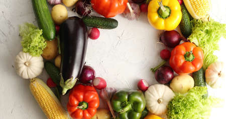 Top view of round layout of various colorful vegetables on white table surface composed in wreathの写真素材