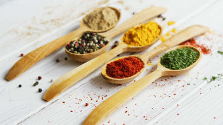 Arrangement of small wooden spoons with assortment of ground spices on wooden tableの写真素材