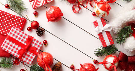 From above shot of various cute Christmas decorations and nicely wrapped gifts forming cute border...