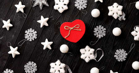 From above view of white beautiful Christmas decorations and present in red box in shape of heart on...