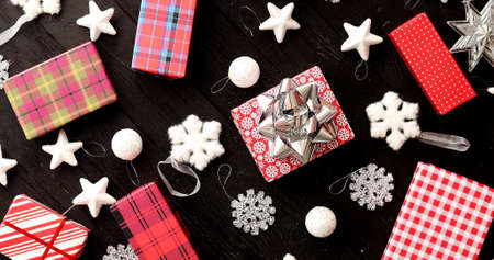 From above view of colorful wrapped presents and Christmas decorations laid on wooden backgroundの写真素材