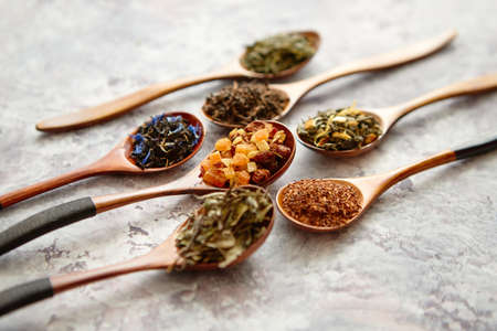 Virious kinds of tea in wooden spoons placed on stone tableの写真素材