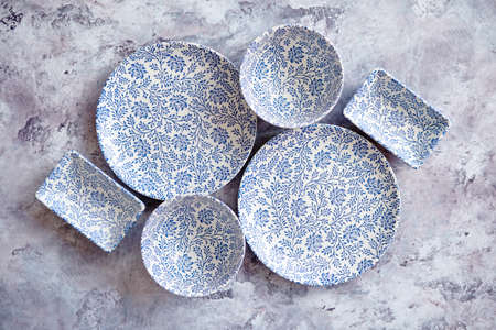 Empty traditional set tableware from Asia. Bowls, plates and soy souce dishes placed on stone...