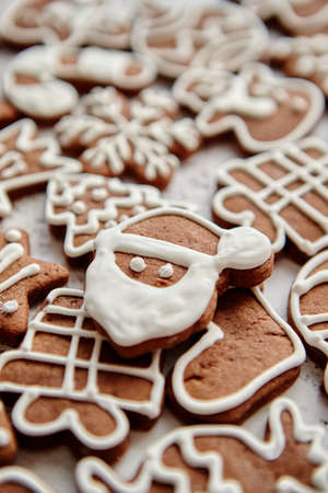 Composition of delicious gingerbread cookies shaped in various Christmas symbols. Placed on white...