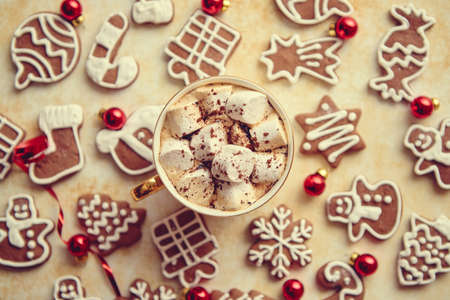 Cup of hot chocolate with tasety marshmellows. Fresh baked Christmas shaped gingerbread cookies on sides. With Xmas decorations. View from above.の写真素材