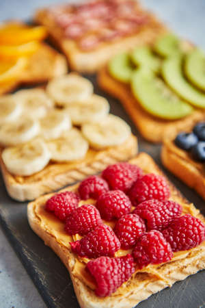 Six Healthy breakfast toasts. Wholegrain bread slices with peanut butter and various fruits. Served...