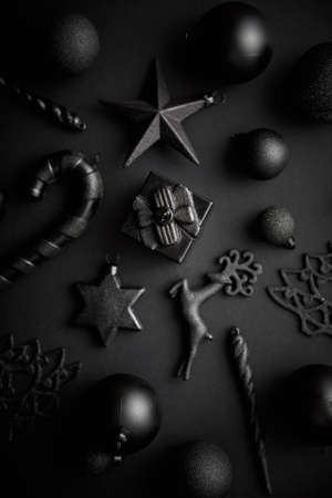Christmas minimalistic and simple composition in mat black color. Christmas gifts, decorations on black background. Flat lay, top view .の写真素材