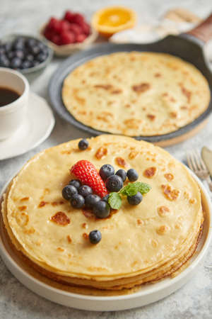 Various breakfast ingredients placed on stone table. With pancakes, muffins, fresh fruits, cupcakes,...
