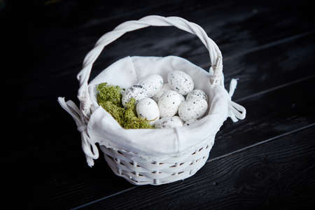 Quail eggs in a nest on a black rustic wooden background. Easter symbols or Healthy food concept.の写真素材