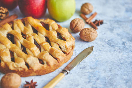 Tasty sweet homemade apple pie cake with cinnamon sticks, walnuts and apples on side. Placed on stone background with copy space.の写真素材