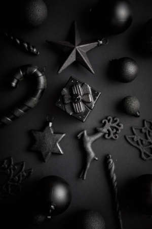 Christmas minimalistic and simple composition in mat black color. Christmas gifts, decorations on black background. Flat lay, top view .の写真素材