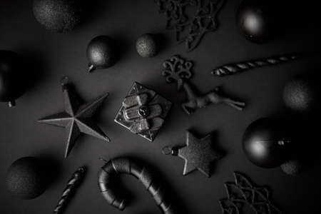 Christmas minimalistic and simple composition in mat black color. Christmas gifts, decorations on black background. Flat lay, top view .の写真素材