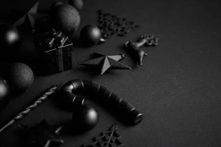 Christmas minimalistic and simple composition in mat black color. Christmas gifts, decorations on black background. Flat lay, top view .の写真素材