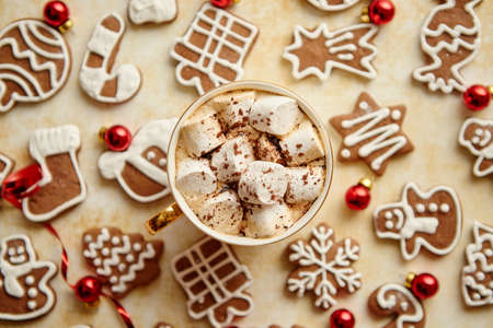 Cup of hot chocolate with tasety marshmellows. Fresh baked Christmas shaped gingerbread cookies on sides. With Xmas decorations. View from above.の写真素材