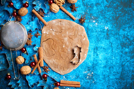 Christmas baking concept. Gingerbread dough with different cutter shapes and spices on sides. Top...