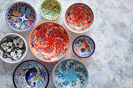 Collection of empty moroccan colorful decorative ceramic bowls. Composition captured from top view, flat lay. Placed on grey stone background.の写真素材