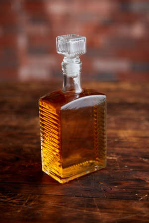 Old vintge photo of Bottle of whiskey on wooden tableの写真素材