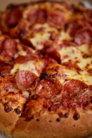 Delicious and appetizing background. Pepperoni pizza closeup with selective focus.の写真素材