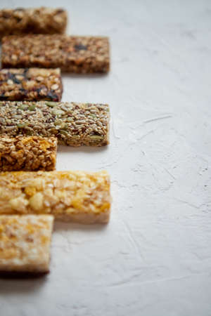 Composition of healthy raw dessert snack. Fitness dietary food. Homemade protein energy natural bars on the rustic white stone board. Vegetarian nutrition concept. Copy space.の写真素材