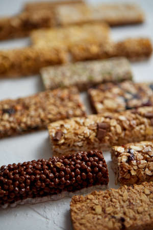 Homemade gluten free granola bars with mixed nuts, seeds, dried fruits on white stone background. Top view.の写真素材