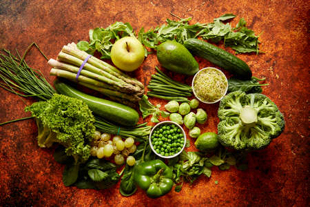 Fresh, natural, green vegetables, fruits and herbs assortment placed on a rusty metal background. Top view.の写真素材