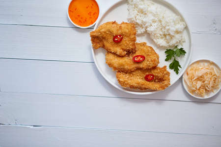 Crispy chicken fried in breadcrumbs served with rice. View from the top on white wooden background. Flat lay.の写真素材