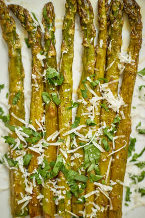 Close up of hot fresh roasted asparagus with parmesan cheese and parsley. Healthy spring food concept. Top view.の写真素材