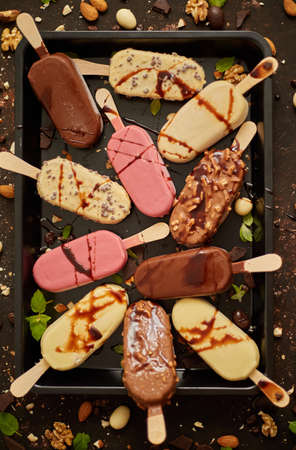 Assortment of various  ice cream, white and dark chocolate,  almonds, on a rusty background  ice. Flat lay, top view.の写真素材