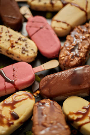 Ice cream on stick coated with various chocolate glazes and toppings. Top view, flat lay. Close up...