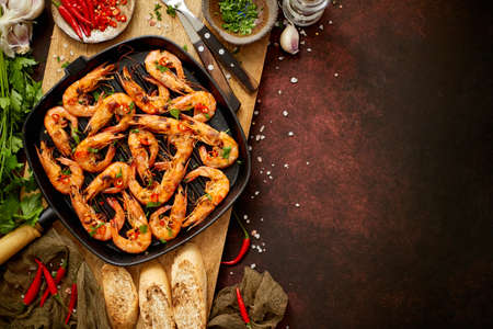 Tasty appetizing roasted shrimps prawns with spices on pan with ingredients on rusty background. Top View with Copy space. Food Background Italian Kitchen Conceptの写真素材