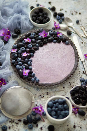 Homemade blackberry tart. Sweet pie with blackberry blueberry and grapes on stone table. Top view flat lay background.の写真素材