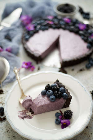 Plate with homemade piece of delicious blueberry, blackberry and grape pie or tart served on table. Top view, flat lay.の写真素材
