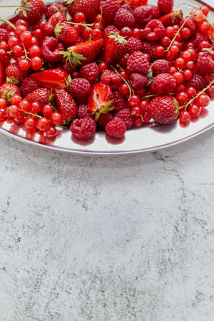 Fresh summer fruit composition. Strawberries, red currants, raspberries placed on metal tray. Top view, flat lay.の写真素材
