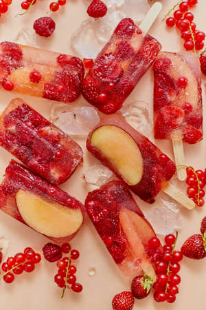 Homemade frozen various red berries natural juice - paletas - ice pops. Overhead, flat lay, top view. Healthy summer snack concept.の写真素材