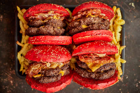 From above yummy burgers with red buns placed on box of french friesの写真素材