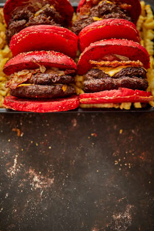 From above yummy burgers with red buns placed on box of french fries. Copy space for textの写真素材
