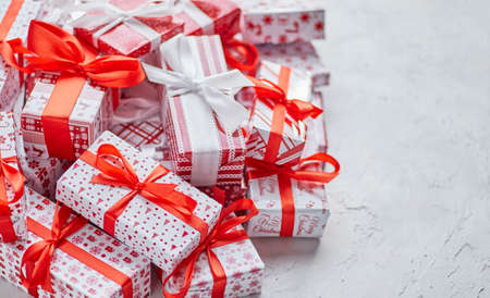 Various pattern and size Christmas boxes placed on white background. Wrapped in festive paperの写真素材