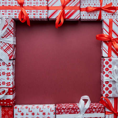 Arranged Gifts boxes wrapped in colorful festive paper with on burgund backgroundの写真素材