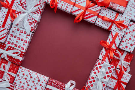 Arranged Gifts boxes wrapped in colorful festive paper with on burgund backgroundの写真素材