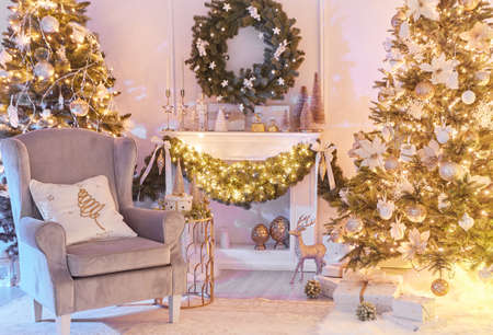 Christmas interior concept. With fireplace, armchair, pine tree, wrapped gifts, lightsの写真素材
