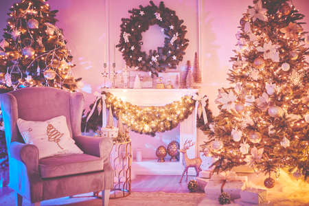 Beautiful Christmas interior decoration for family celebration with pine tree, armchair, fireplaceの写真素材