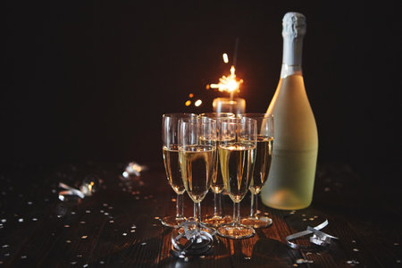 Party composition image. Glasses filled with champagne placed on black tableの写真素材