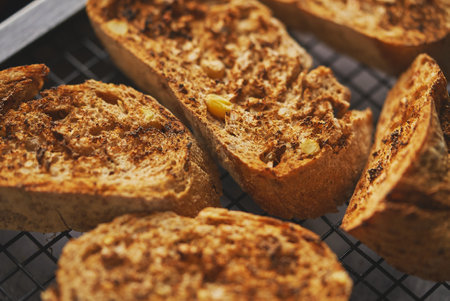 Close up marcor shot of toasted baguette slices placed on grill frame. Top view