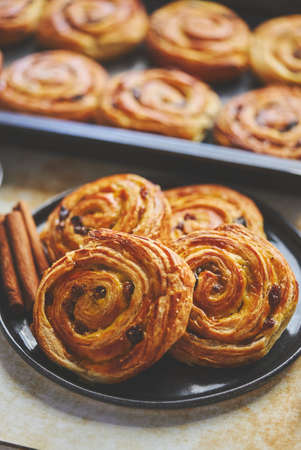 Delicious, fresh baked cinnamon buns served on black ceramic plate. With various sidesの写真素材