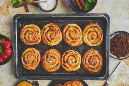 Fresh baked cinnamon buns on black iron tray. Top viewの写真素材